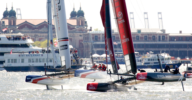 Emirates TNZ tries to hold off a flying Groupama Team France.  Ellis Island is in the background.
